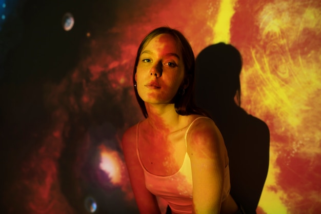 Młoda kobieta stojąca w projekcji tekstury wszechświata