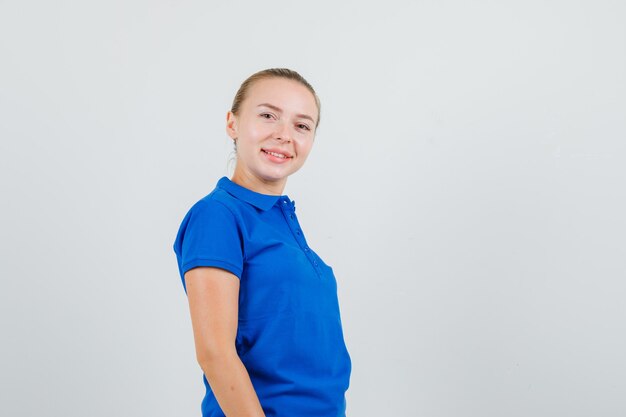 Młoda kobieta szuka w niebieskiej koszulce i cieszy się