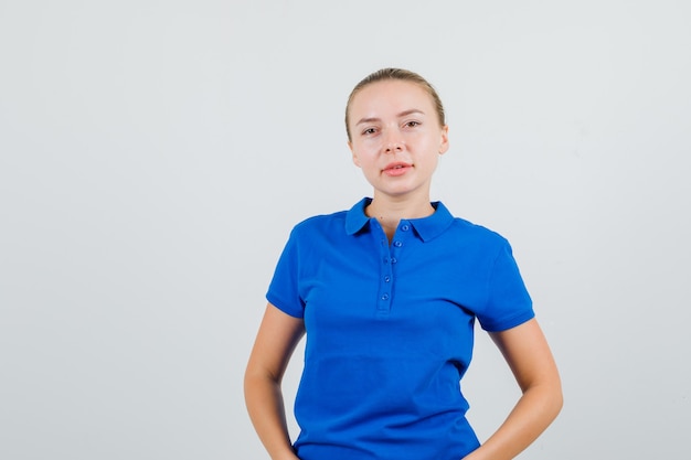 Bezpłatne zdjęcie młoda kobieta szuka w niebieskiej koszulce i wygląda rozsądnie