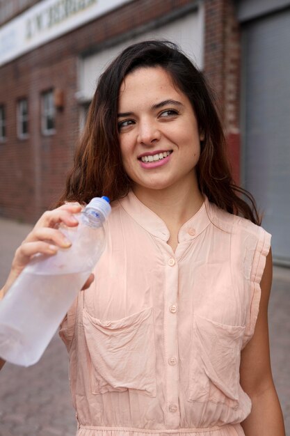 Bezpłatne zdjęcie młoda kobieta tolerująca falę upałów z chłodnym napojem