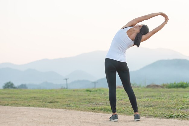 Młoda kobieta treningu przed treningiem fitness w parku.