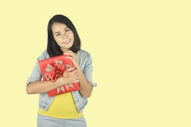 Młoda kobieta trzyma czerwone pudełko prezent na urodziny walentynki koncepcja boże narodzenie nowy rok