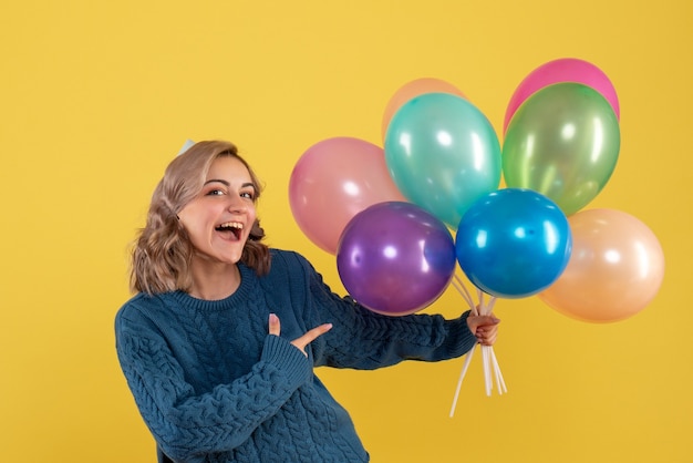 młoda kobieta trzyma kolorowe balony na żółto