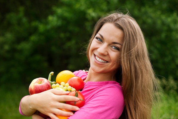 Bezpłatne zdjęcie młoda kobieta trzyma owoce i warzywa