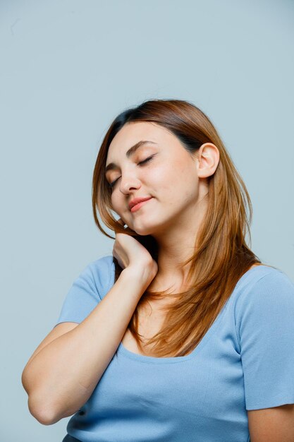 Młoda kobieta trzyma rękę na szyi i wygląda na zaspaną