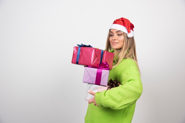 Młoda kobieta trzyma w rękach świąteczne prezenty.