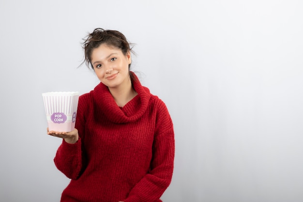 Bezpłatne zdjęcie młoda kobieta trzyma wiadro popcornu.