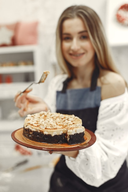 Młoda kobieta trzyma własnoręcznie wykonane ciasto w kuchni