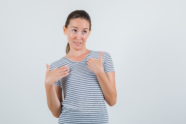Młoda kobieta trzymając się za ręce w pytającym geście w widoku z przodu t-shirt w paski.