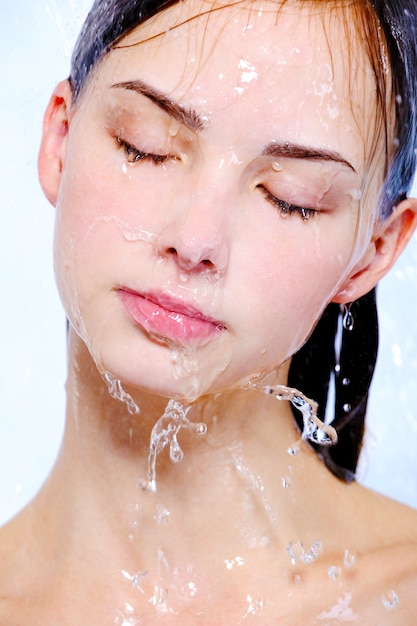 Młoda kobieta twarz strumieniem wody na twarzy - traktat uzdrowiskowy