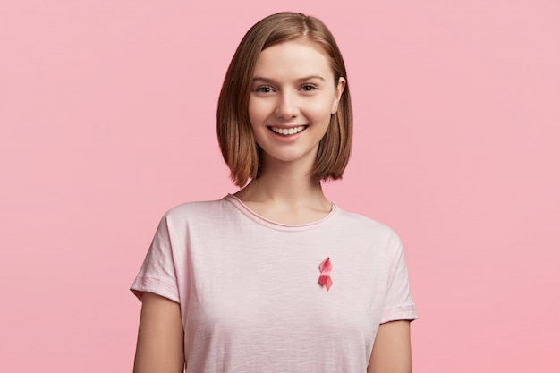 Bezpłatne zdjęcie młoda kobieta ubrana na różową wstążkę świadomości raka piersi