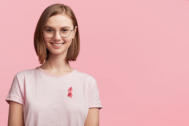 Młoda kobieta ubrana na różową wstążkę świadomości raka piersi