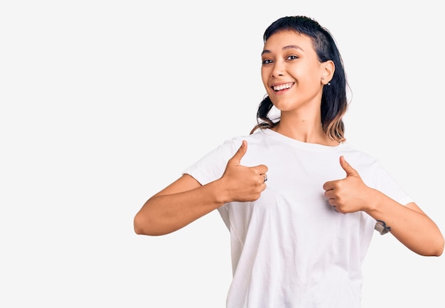 Młoda kobieta ubrana w przypadkowe ubrania znak sukcesu robi pozytywny gest z kciukami w górę uśmiechniętym i szczęśliwym wesołym wyrazem twarzy i gestem zwycięzcy