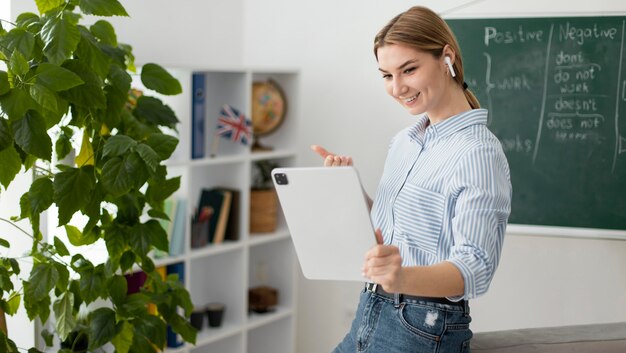 Młoda kobieta uczy studentów w klasie angielskiego online