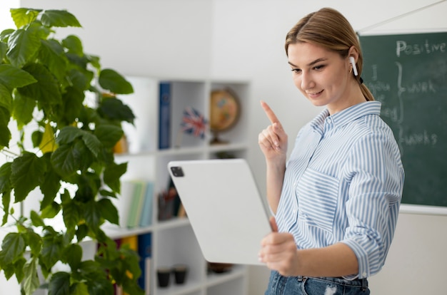 Bezpłatne zdjęcie młoda kobieta uczy studentów w klasie angielskiego online