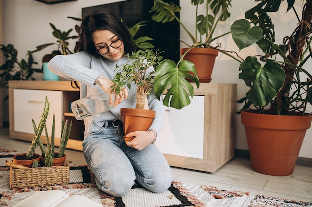 Bezpłatne zdjęcie młoda kobieta uprawia rośliny w domu