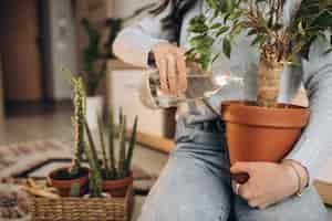 Bezpłatne zdjęcie młoda kobieta uprawia rośliny w domu