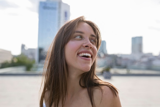Bezpłatne zdjęcie młoda kobieta uśmiecha się na zewnątrz