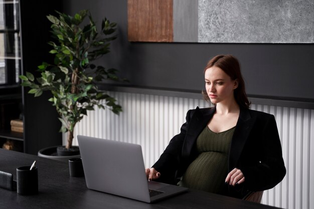 Młoda kobieta w ciąży w pracy