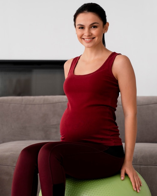 Młoda kobieta w ciąży za pomocą piłki fitness