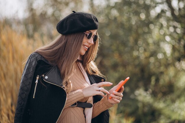 Młoda kobieta w ciąży za pomocą telefonu