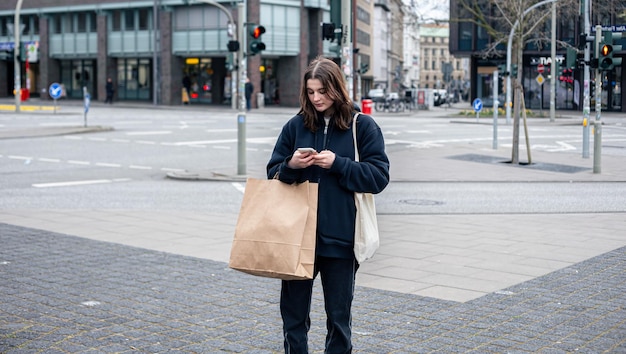 Młoda kobieta w mieście na ulicy z koncepcją zakupów pakietowych