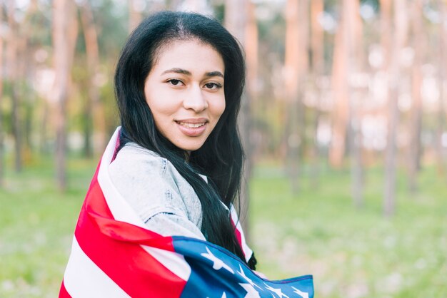 Młoda kobieta w parku z flaga USA