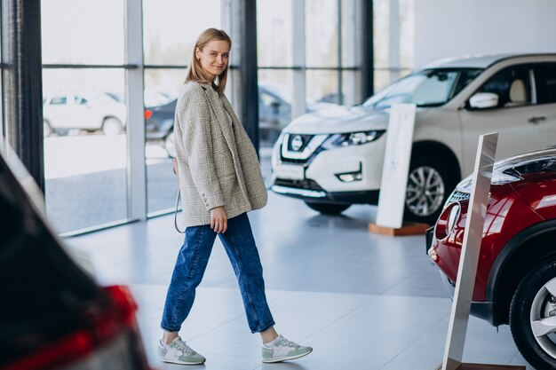 Młoda kobieta wybiera samochód w samochodowej sala wystawowej