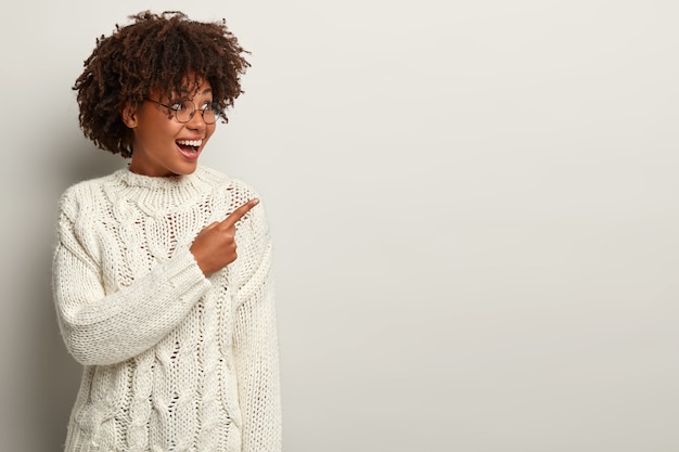 Młoda kobieta z fryzurą Afro na sobie biały sweter