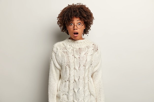 Młoda kobieta z fryzurą Afro na sobie biały sweter