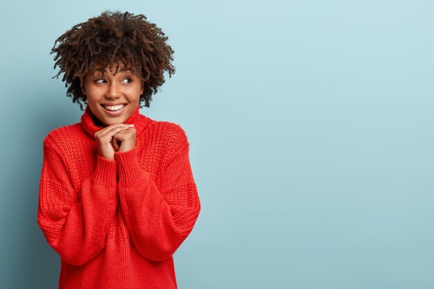 Młoda kobieta z fryzurą Afro na sobie czerwony sweter