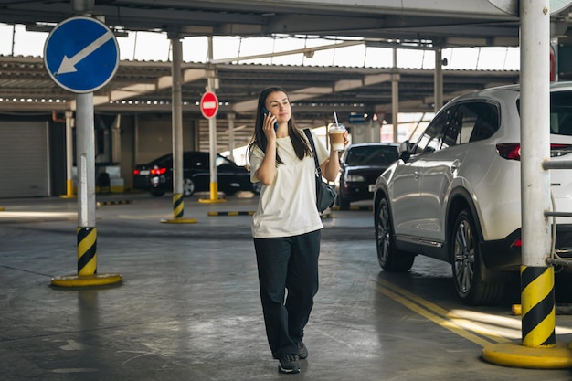 Młoda Kobieta Z Kawą Rozmawia Przez Telefon Na Parkingu