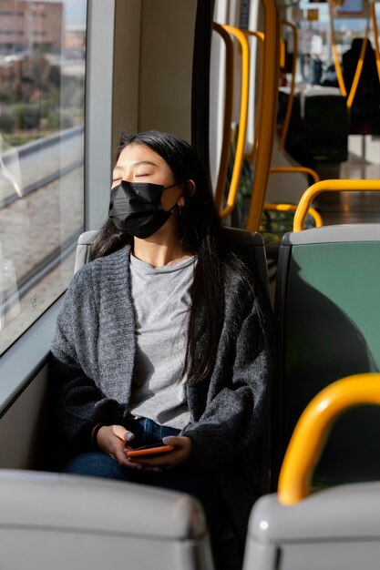 Młoda kobieta z maską w autobusie