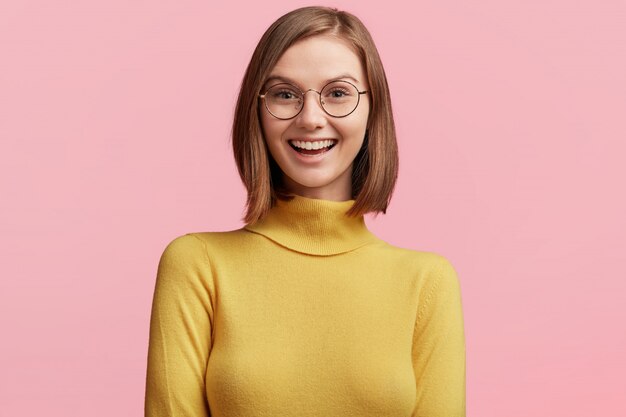 Młoda kobieta z okrągłymi szkłami i żółtym swetrem