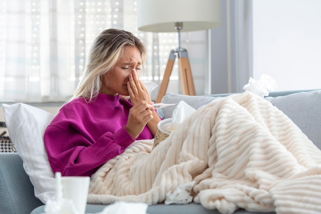 Młoda kobieta złapana przeziębieniem lub grypą Portret niezdrowej dziewczyny wydmuchującej nos