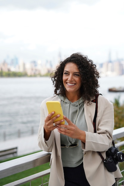 Młoda kobieta zwiedzająca miasto podczas korzystania ze smartfona