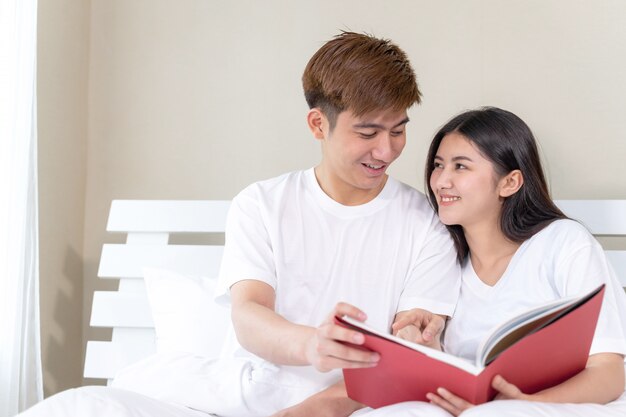 Młoda ładna kobieta i przystojny chłopak czytanie książek na łóżku w domu