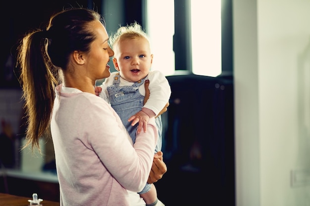 Młoda mama bawi się z synkiem podczas wspólnego spędzania czasu w domu