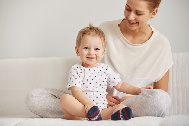 Młoda mama z rocznym synkiem ubrana w piżamę odpoczywa