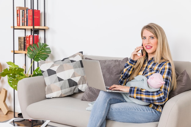 Młoda Matka Z Dzieckiem Rozmawia Przez Telefon I Za Pomocą Laptopa