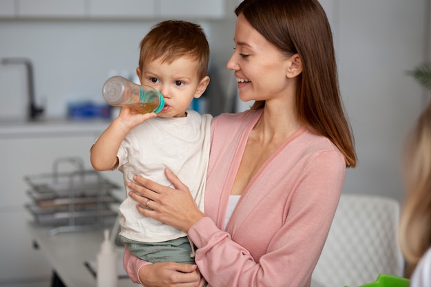 Bezpłatne zdjęcie młoda matka z maluchem u pediatry na badanie fizykalne