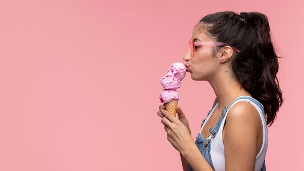 Młoda nastolatka jedząca lody w okularach przeciwsłonecznych