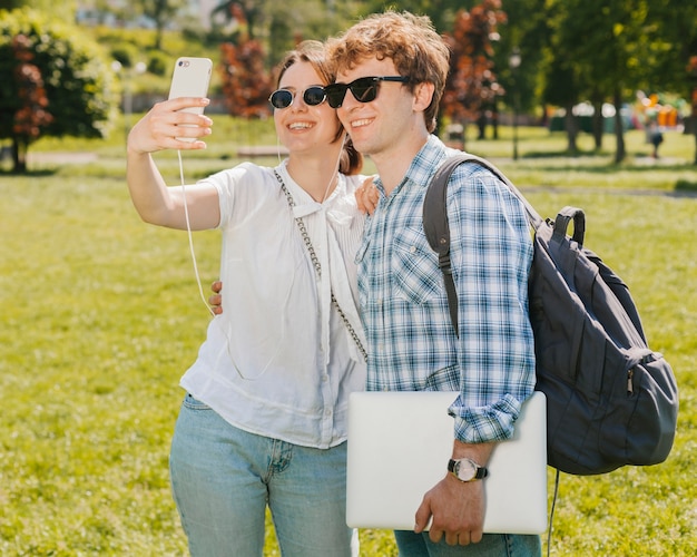 Bezpłatne zdjęcie młoda para biorąc selfie w parku