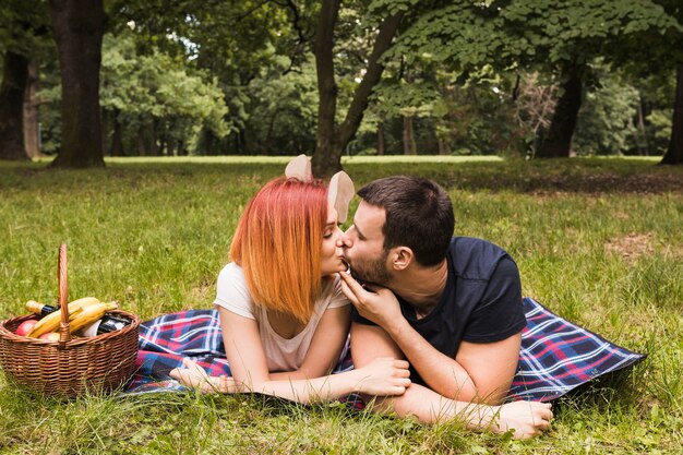 Młoda para całuje razem na piknik w parku