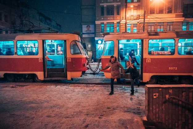 Młoda para dorosłych na pokryte śniegiem przystanku tramwajowego