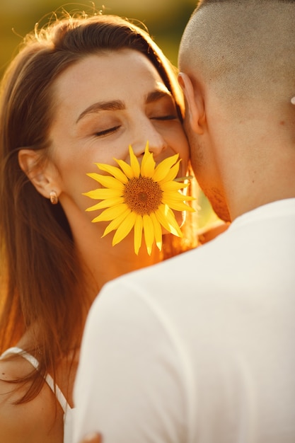Młoda para kochających się całuje się w słonecznikowym polu. Portret para stwarzających latem w polu.