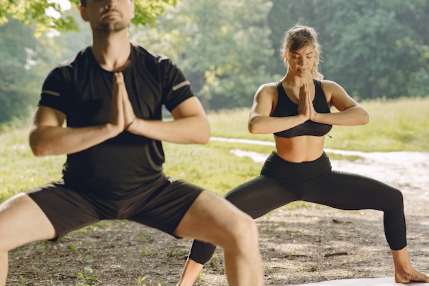 Młoda Para Sprawny Robi Joga Fitness. Ludzie W Letnim Parku.