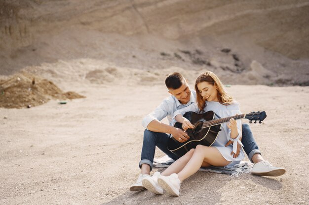 Młoda para w miłości, chłopak gra na gitarze