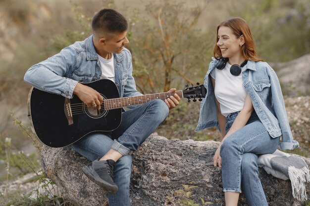 Młoda para w miłości, chłopak gra na gitarze