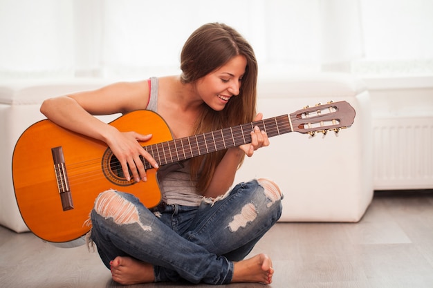 Młoda piękna kobieta gra na gitarze